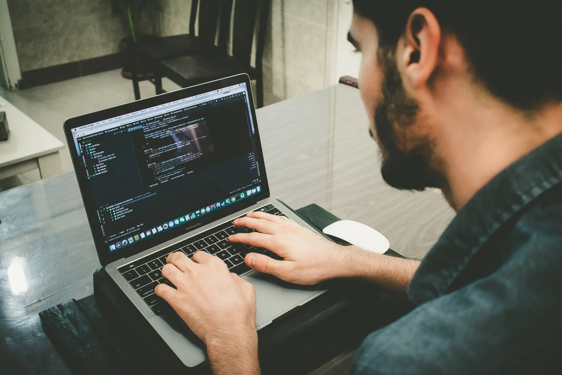 Man coding in JAVA programming language on a MacBook laptop